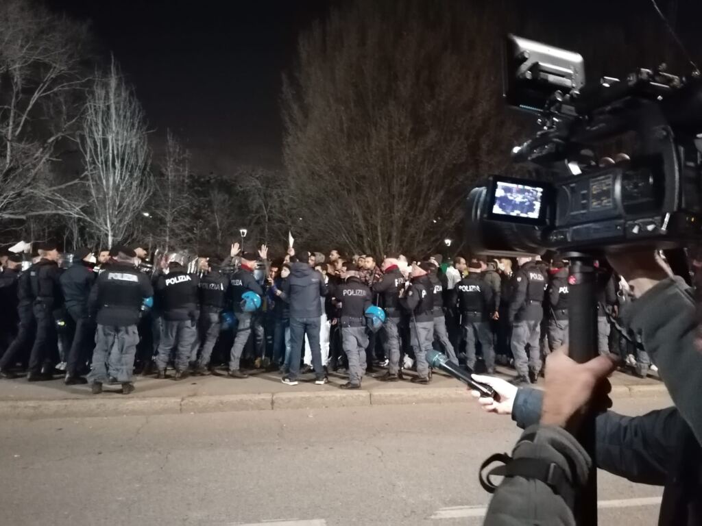 folla di polizia e stranieri a Milano